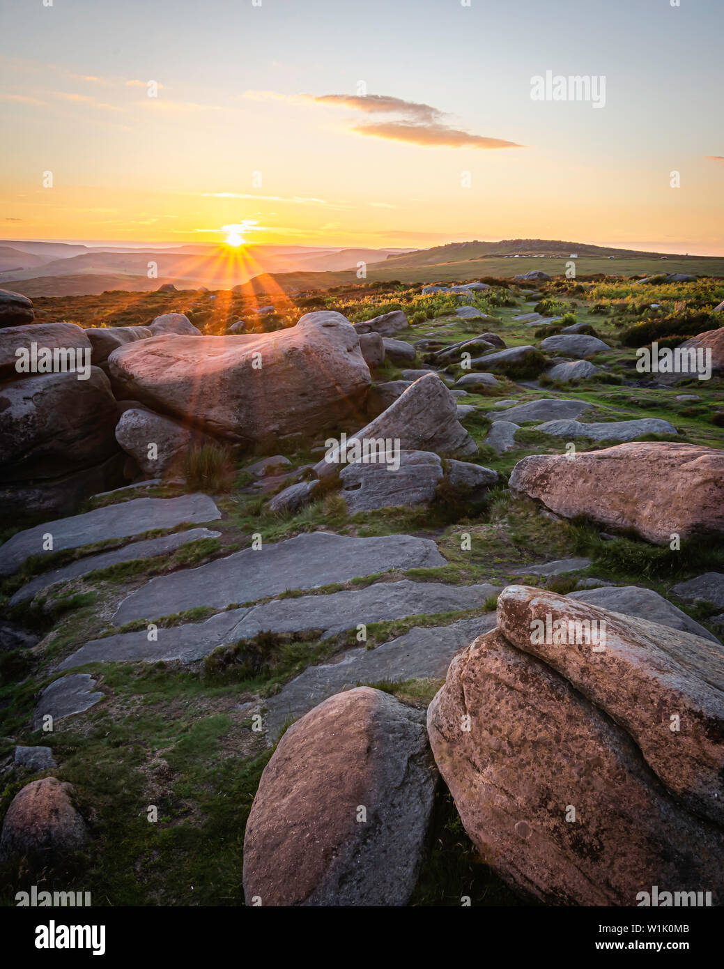 Scène Coucher du soleil dans les régions rurales de Peak District, Derbyshire, UK.des pierres en haut de la colline éclairée par horizon soleil derrière.Ethereal soir paysage.ima Paysage Banque D'Images