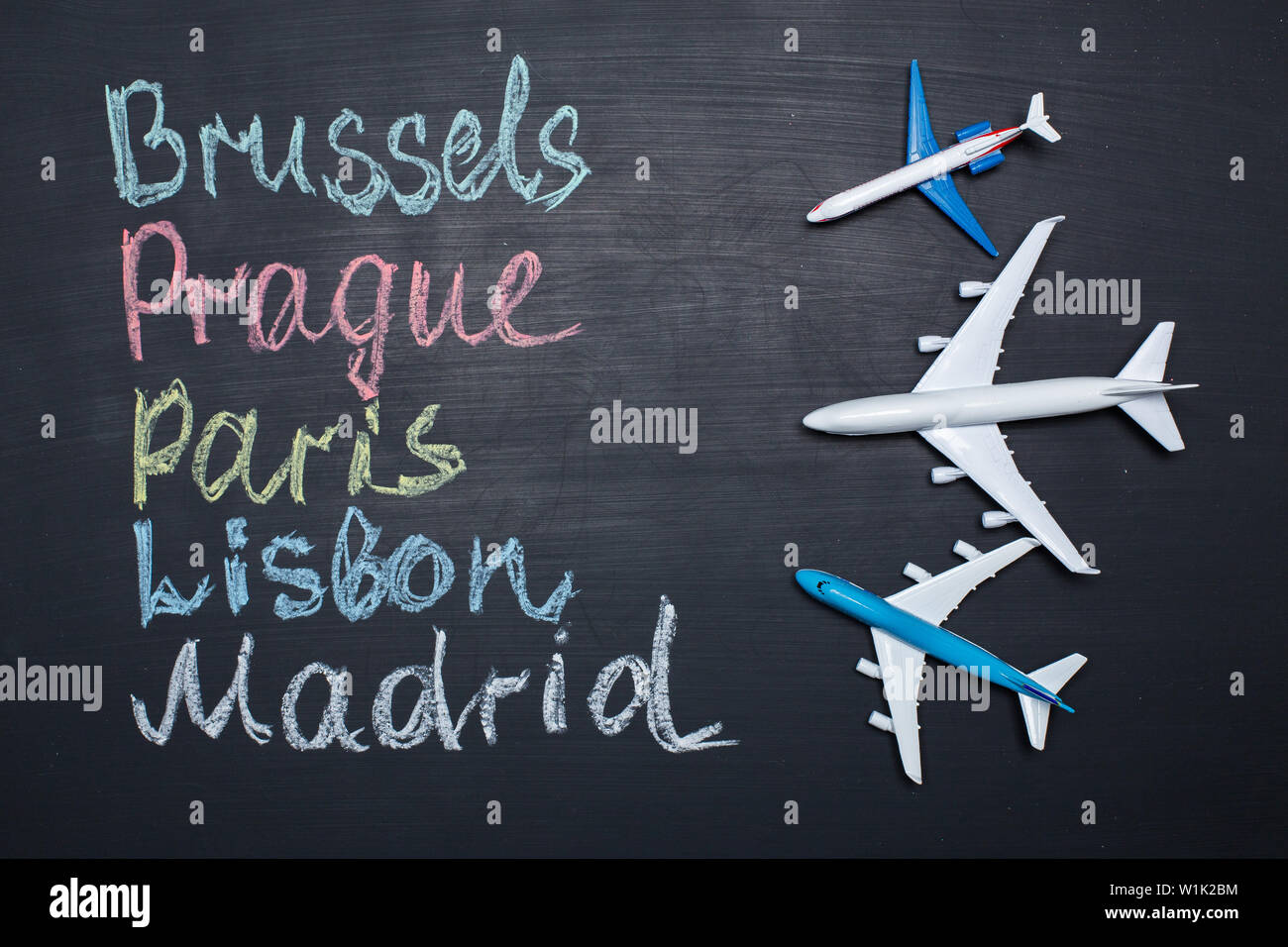 Concept de voyage. Avion jouet sur tableau avec les villes écrit dessus Banque D'Images