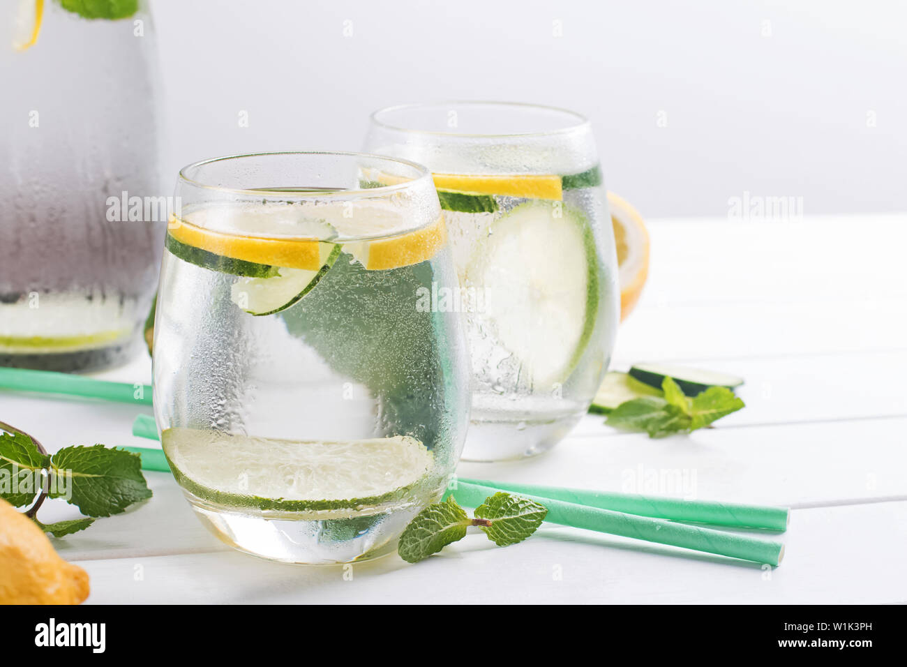 Deux verres d'eau infusée de menthe, citron et cucucmber sur la table en bois blanc Banque D'Images