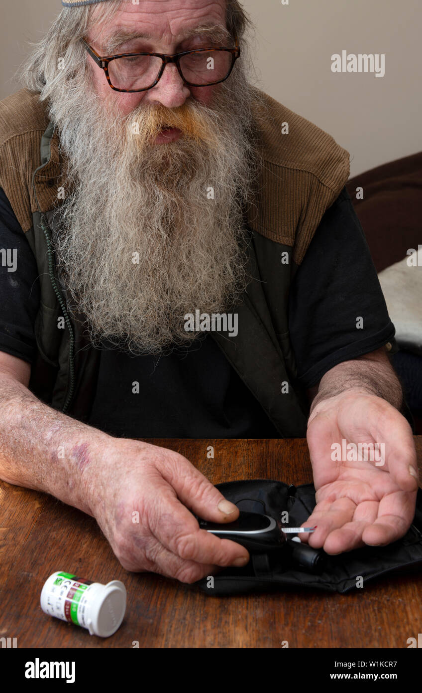 Un homme âgé avec le type 2 diabeties effectuant un test de glycémie Banque D'Images