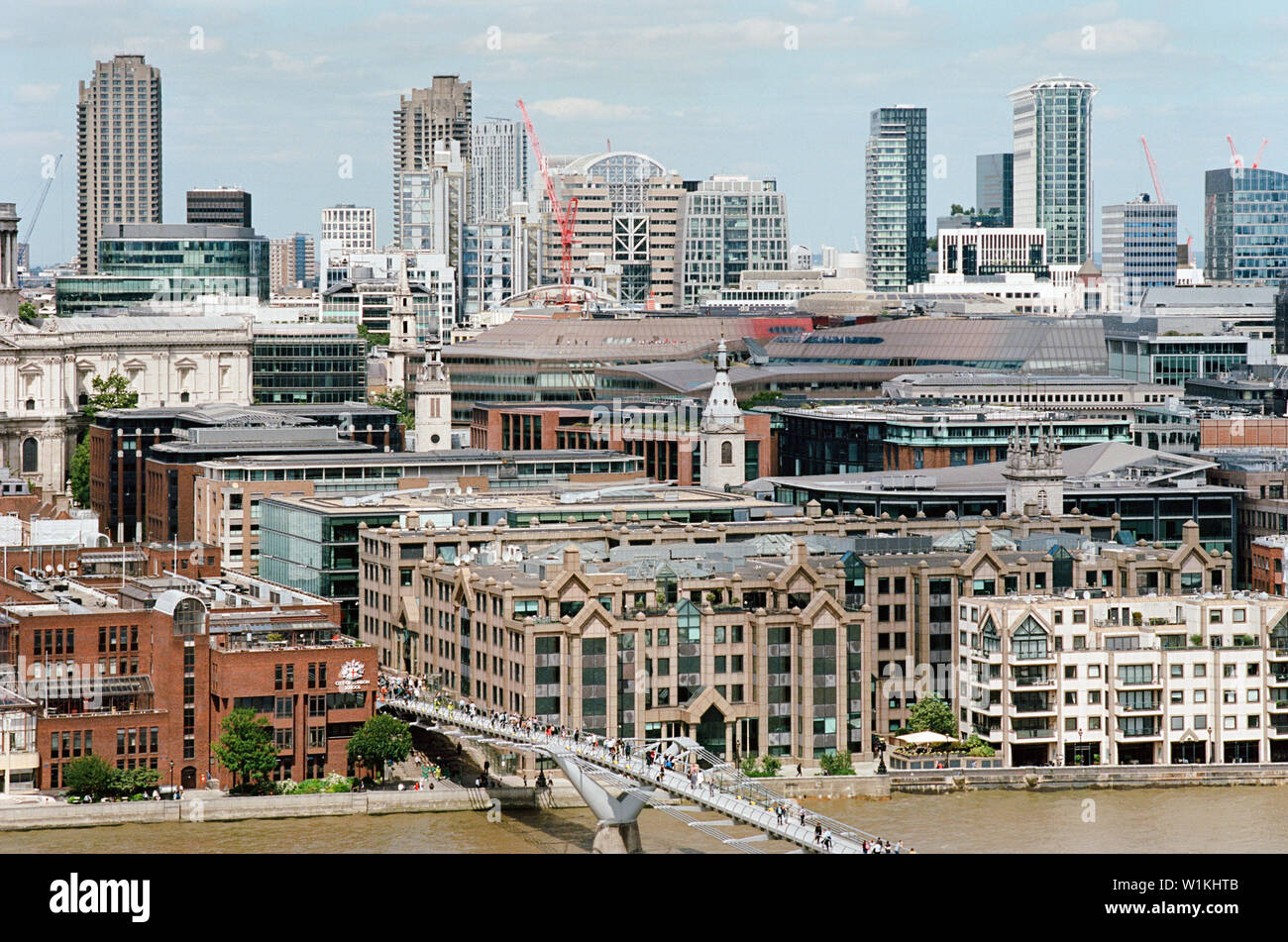 Ville de London et le Barbican vue depuis le dernier étage de la Tate Modern, avec des gens qui marchent sur le pont du millénaire Banque D'Images