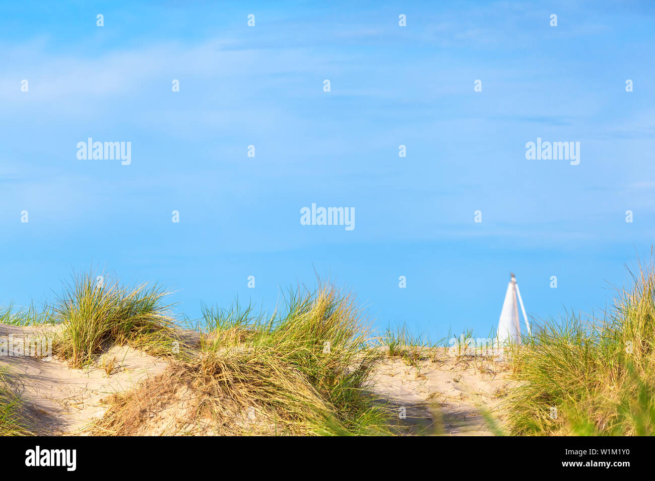 Paysage de dunes à la mer Baltique, de voile blanche voilier derrière, vaste ciel copy space Banque D'Images