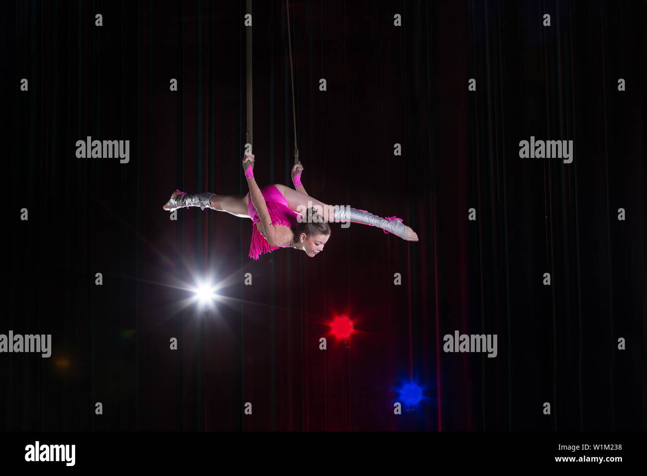 Artiste de cirque acrobat performances. La jeune fille effectue des éléments acrobatiques dans l'air. Gymnaste de cirque sur la scène Banque D'Images