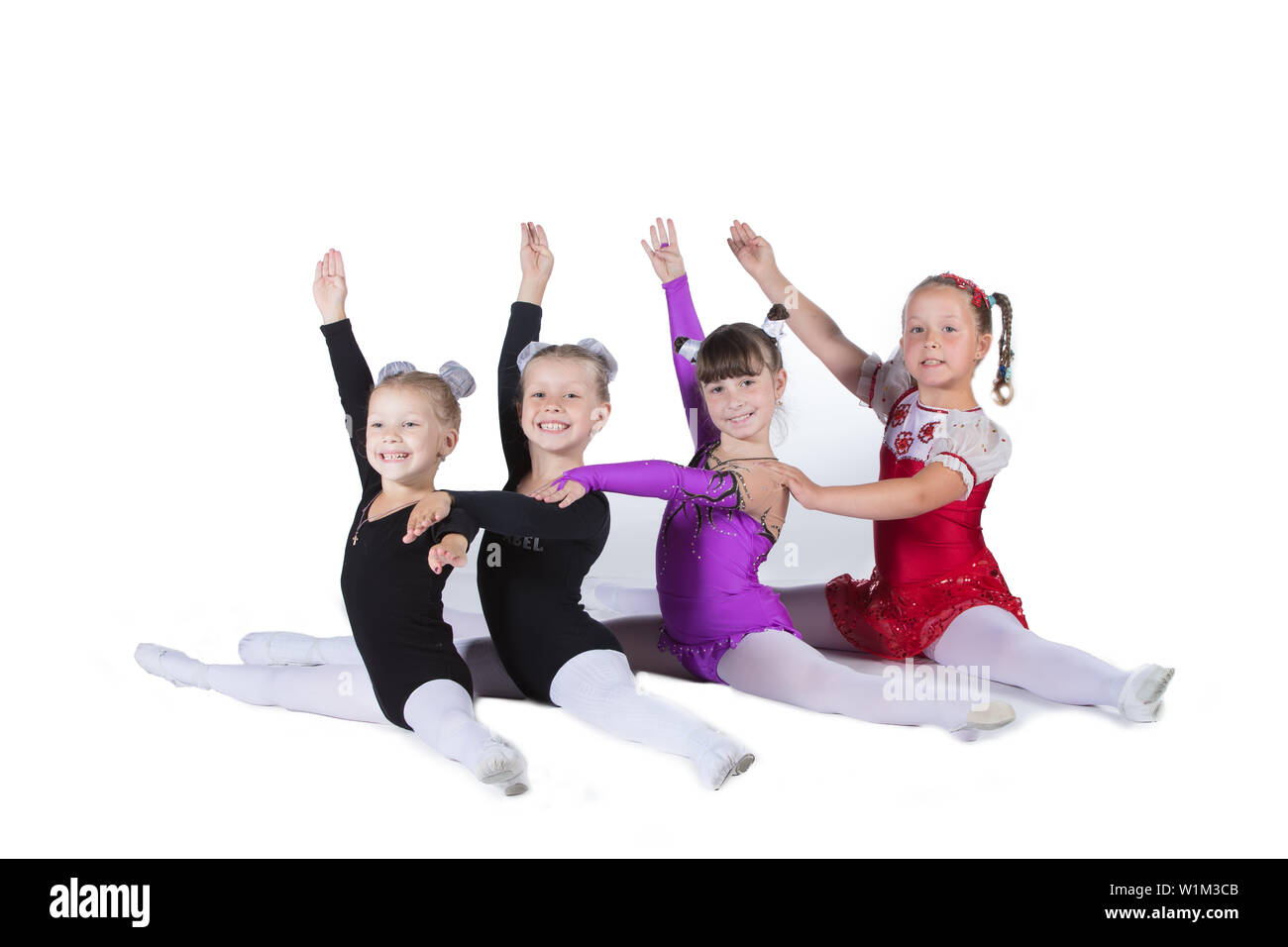 Les gymnastes filles sur un fond blanc. Quatre petits acrobates sur la chaîne. Banque D'Images