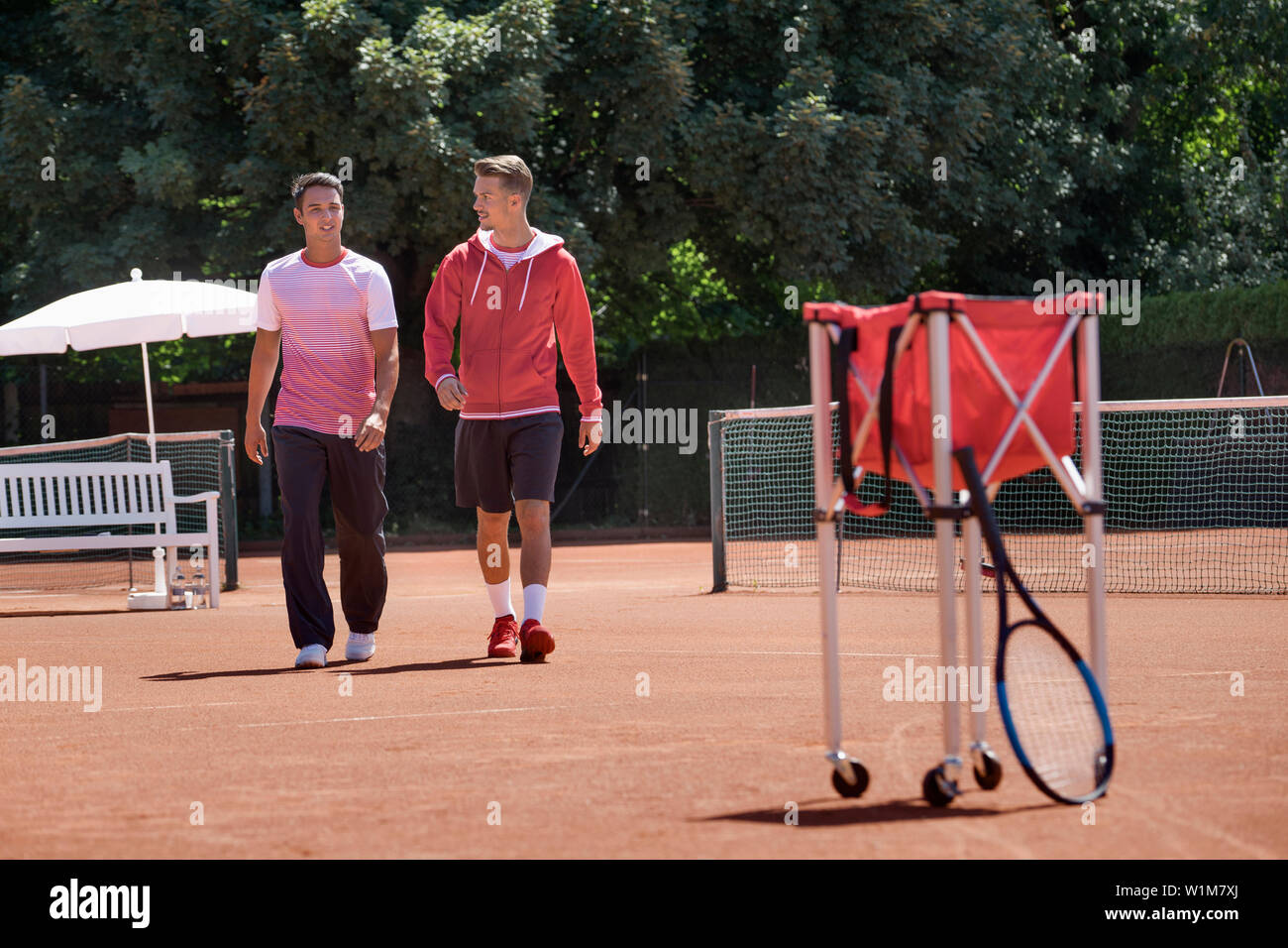 Deux jeunes hommes marchant sur tennis, Bavière, Allemagne Banque D'Images