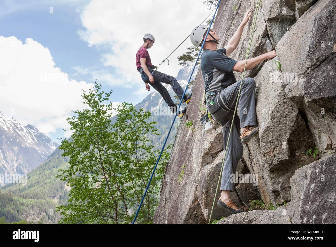 Deux hommes des grimpeurs à l'échelle d'une paroi rocheuse à Oberried jardin d'escalade, l'Otztal, Tyrol, Autriche Banque D'Images