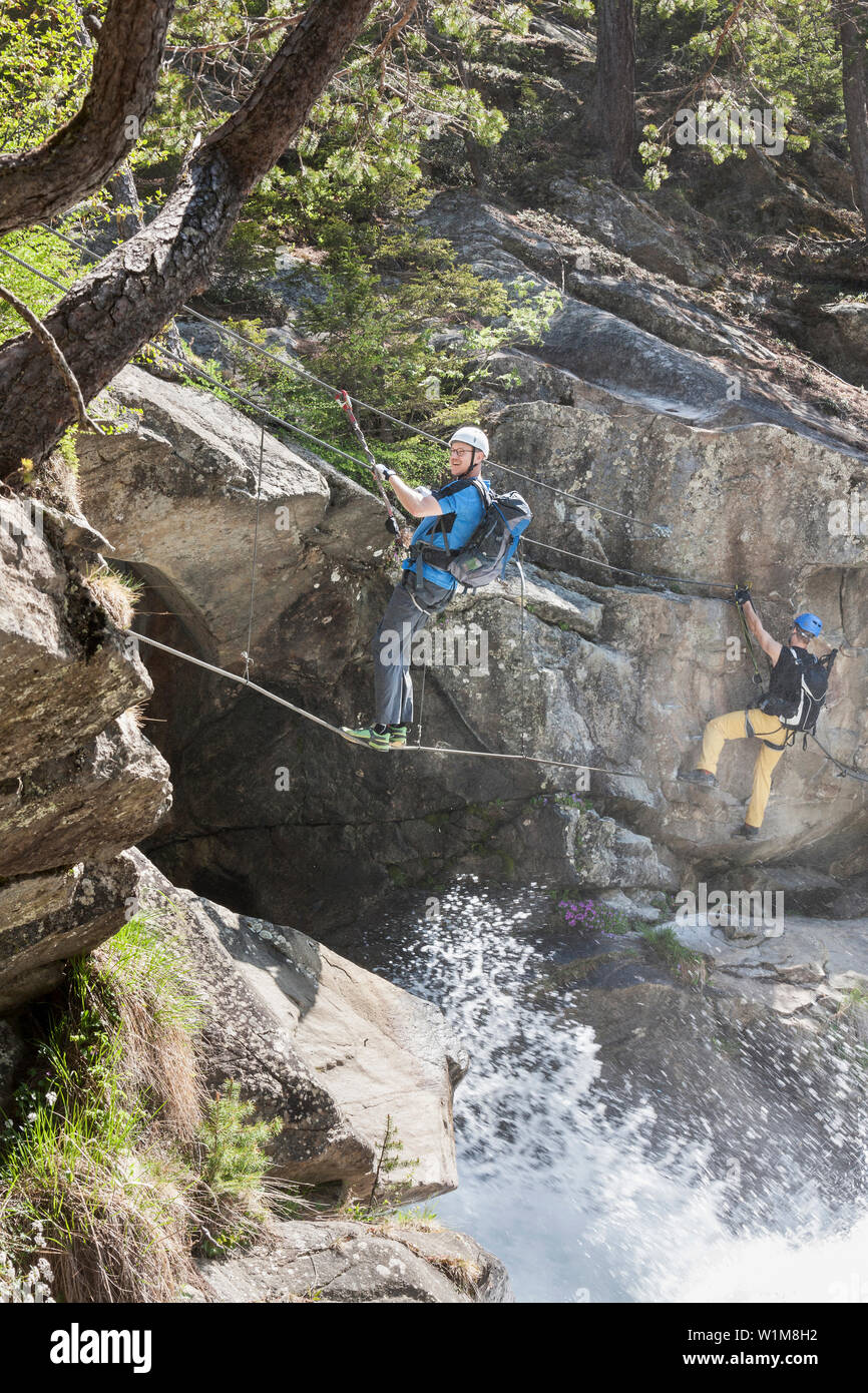 Les hommes climbing rock via ferrata vers Cascade Stuibenfall, Otztal, Tyrol, Autriche Banque D'Images