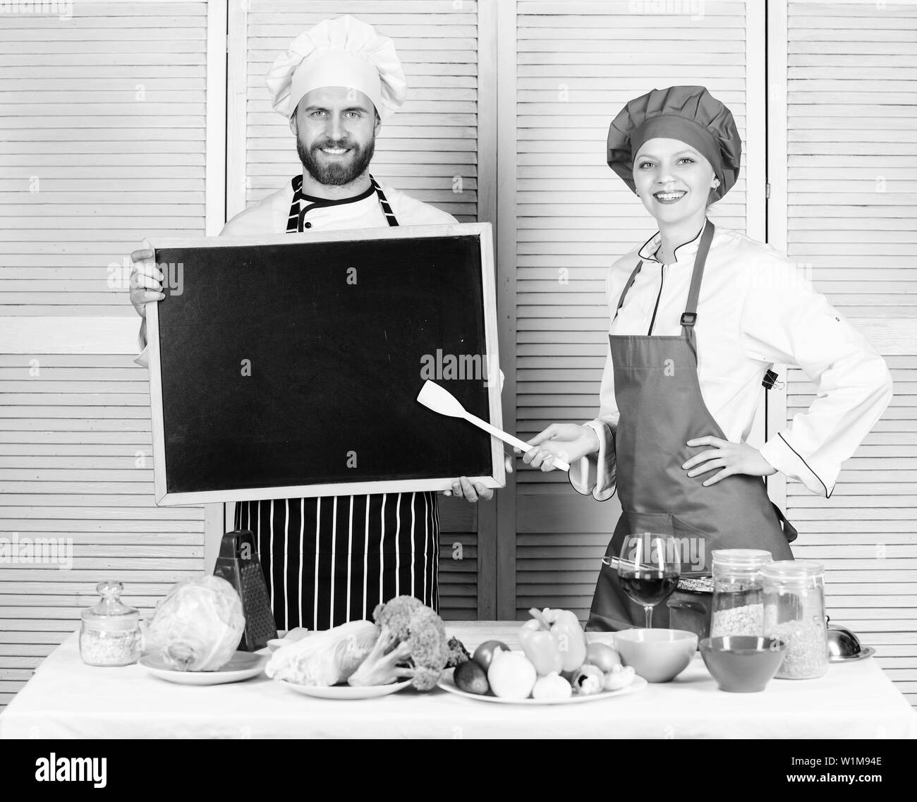 Ouverture bientôt. L'embauche du personnel. La femme et l'homme chef tenir copie tableau noir l'espace. Position de travail. Délicieux repas de cuisine recette. Menu de cuisine pour aujourd'hui. Plat de cuisson Liste des ingrédients. Restaurant familial. Banque D'Images