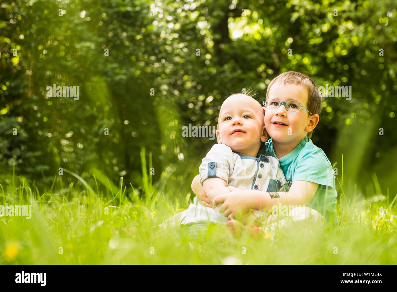 Deux petits frères assis dans le jardin Banque D'Images