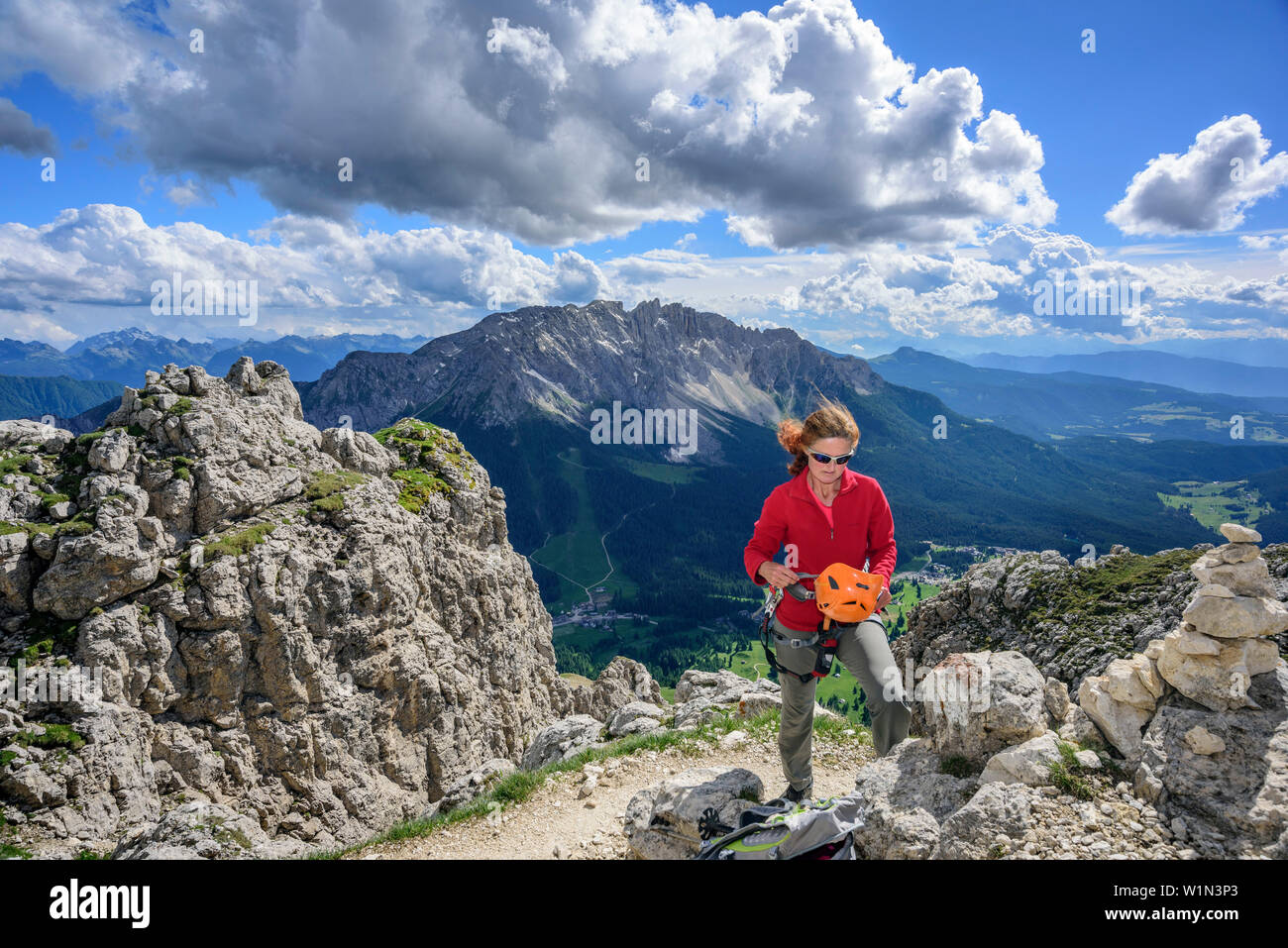 Woman putting on casque d'escalade, route de corde fixe, Masare Masare, Rotwand, Rosengarten, UNESCO World Heritage Dolomites, Dolomites, Trentin, Italie Banque D'Images