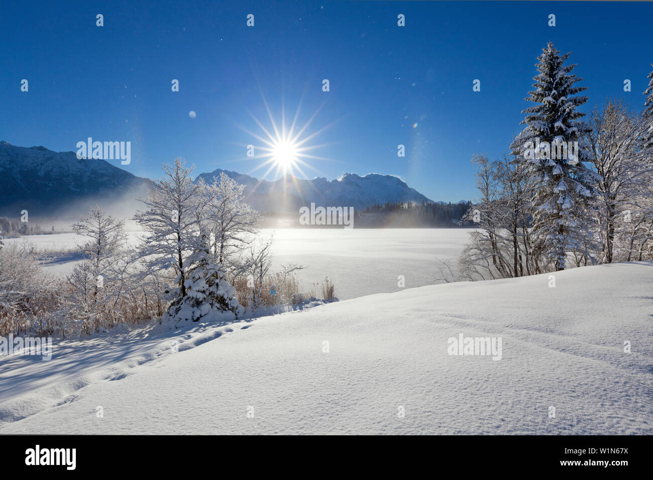 Halo (effet arc-en-ciel produit par frost mist en l'air), paysage d'hiver à Barmsee, vue de Soiern et gamme gamme Karwendel, Bavière, Allemagne Banque D'Images