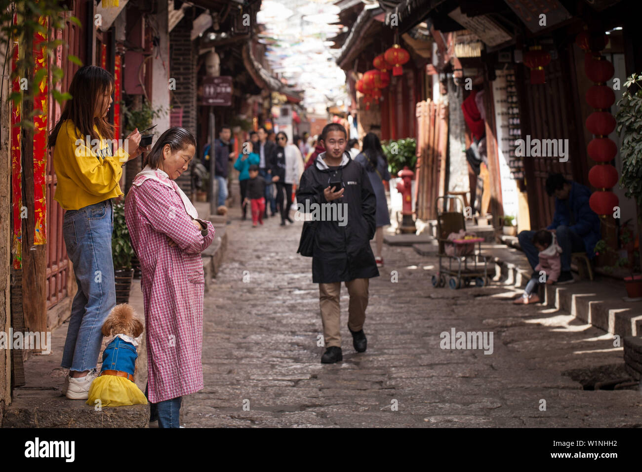Colorants fille sa mère poils sur la rue animée de l'ancienne ville de Lijiang, Yunnan, Chine la providence Banque D'Images