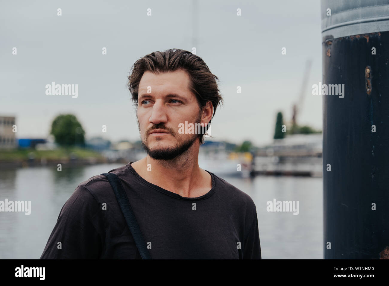 Photographe hipster élégant dans une grande ville avec un appareil photo et un sac à dos sur son dos. Banque D'Images