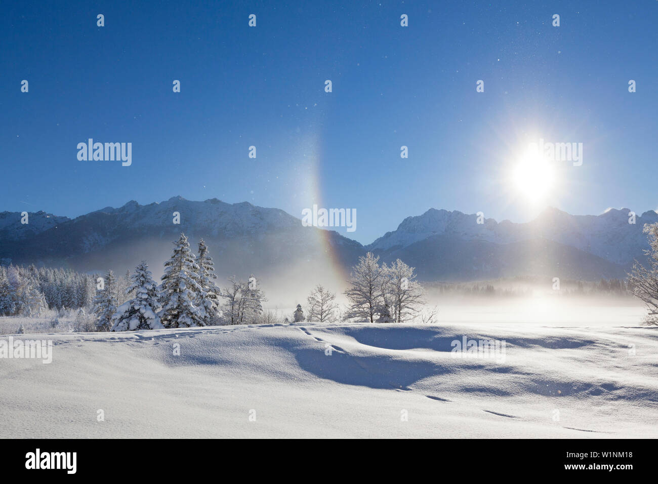 Halo (effet arc-en-ciel produit par frost mist en l'air), paysage d'hiver à Barmsee, vue de Soiern et gamme gamme Karwendel, Bavière, Allemagne Banque D'Images