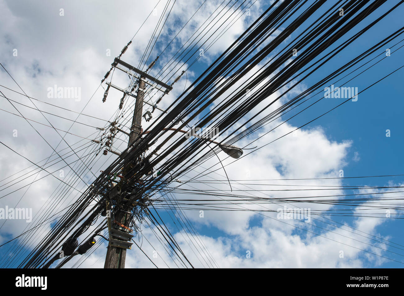 Plusieurs dizaines d'équipements électriques et d'autres fils convergent à un poteau de ciment, Puerto Montt, Los Lagos, en Patagonie, au Chili, en Amérique du Sud Banque D'Images