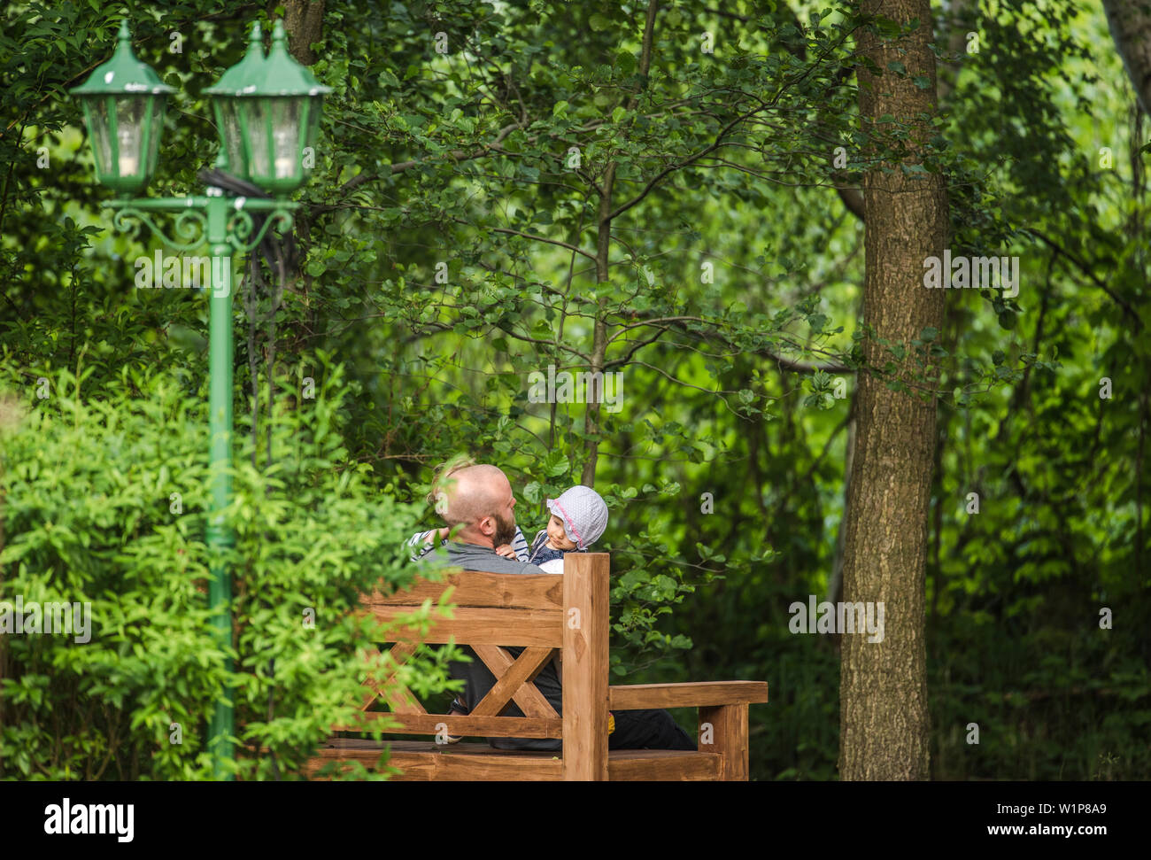 Père et deux enfants assis sur un banc dans le jardin, maison de vacances, vacances, été, Spreewald, Oberspreewald, Brandenburg, Allemagne Banque D'Images