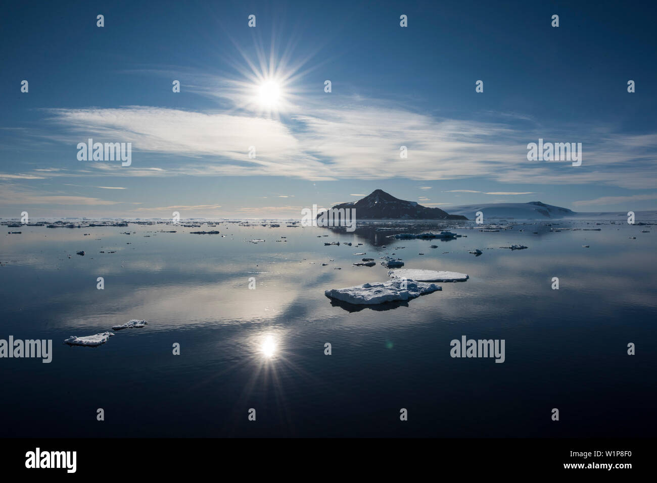 Un soleil radieux brille sur un paysage marin avec des eaux calmes, la mer de glace et d'une île lointaine, l'île Paulet, Péninsule Antarctique, l'Antarctique Banque D'Images