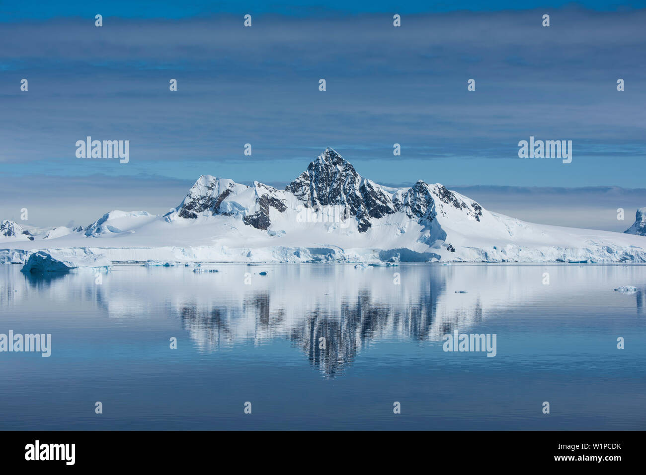 Dans un rare moment pratiquement dépourvu de vent, une image inversée des montagnes neige-couvertes avec un pic élevé, l'oeil enchante, Wilhelmina Bay, l'Antarc Banque D'Images