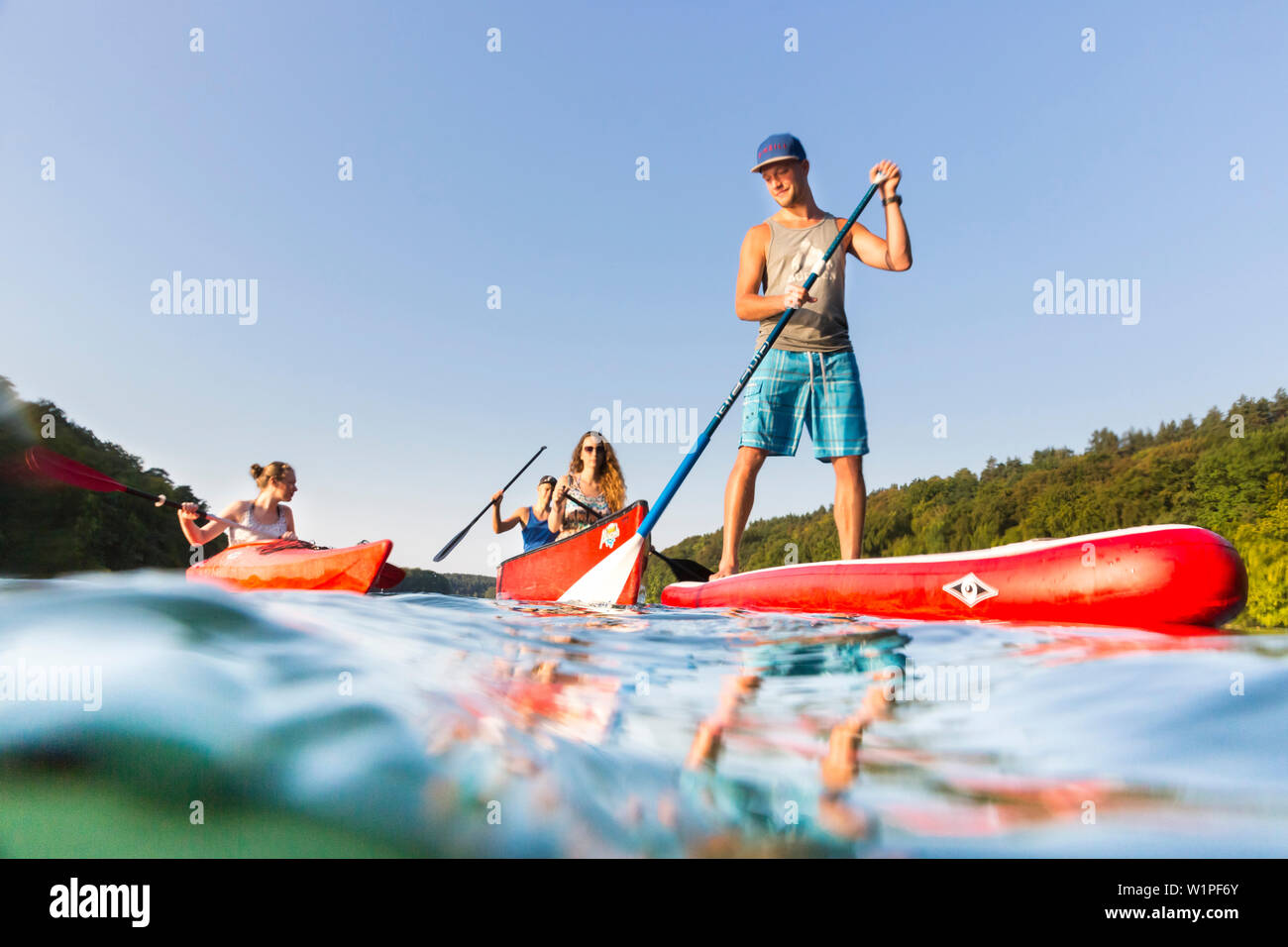 Stand up Paddling, sur le lac, avec palettes de garçon rouge, SUP, in red voile, canot, kayak, sports nautiques, clair comme de l'eau verte, lac Schmaler Luzin, ho Banque D'Images