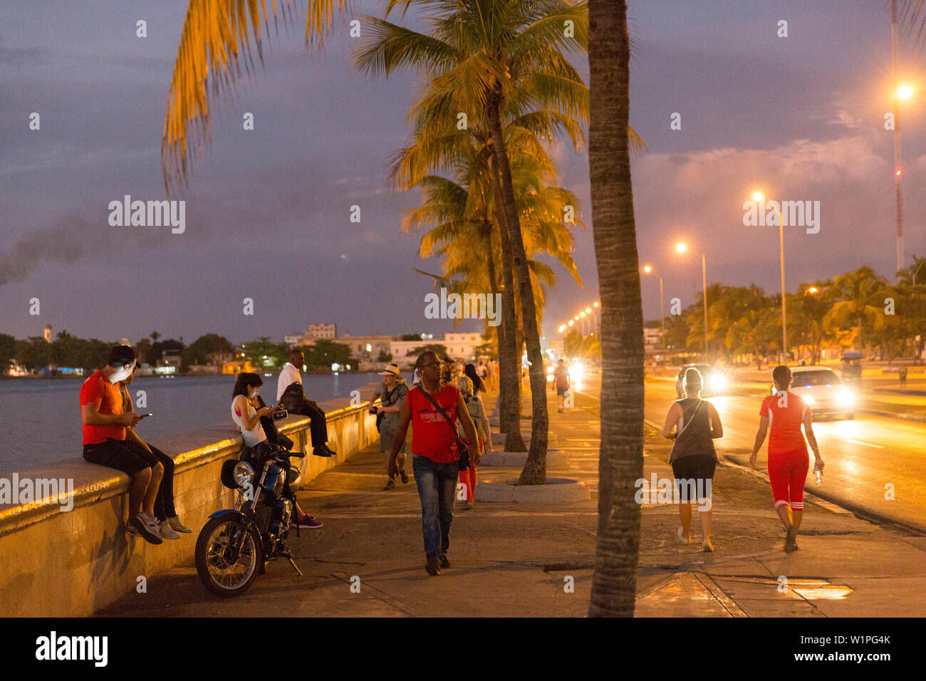 Oldtimer roulant le long du Malecon de Cienfuegos, point de rencontre dans la soirée et la nuit, la vie nocturne, la rue vide, palmier, ville coloniale, la famille Banque D'Images
