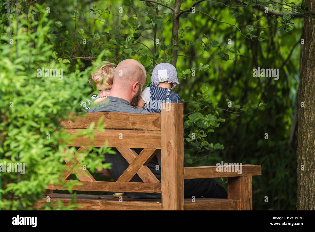 Père et deux enfants assis sur un banc dans le jardin, maison de vacances, vacances, été, Spreewald, Oberspreewald, Brandenburg, Allemagne Banque D'Images