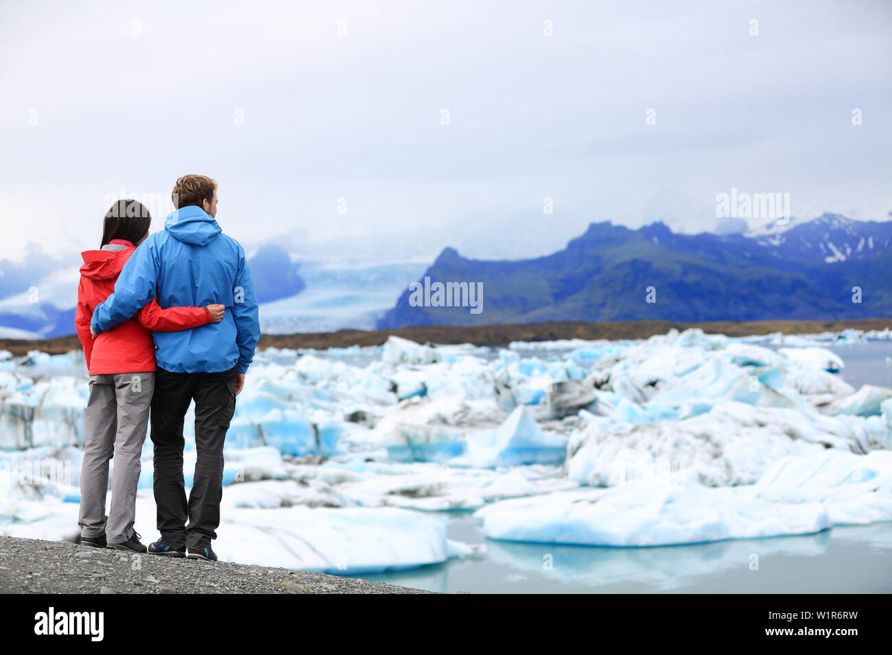 Couple de touristes sur l'Islande romantique lagune glaciaire du Jökulsárlón / lac glacier. Vie active woman and man enjoying view de belle nature paysage islandais Vatnajokull backround dans avec. Banque D'Images