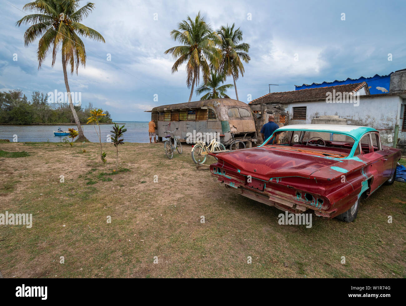 Parcelle de terrain à côté de chambre avec bus abandonné, utilisé comme un magasin, et vieille voiture américaine dans la petite ville de Caleton sur la côte sud de Cuba, des Caraïbes Banque D'Images