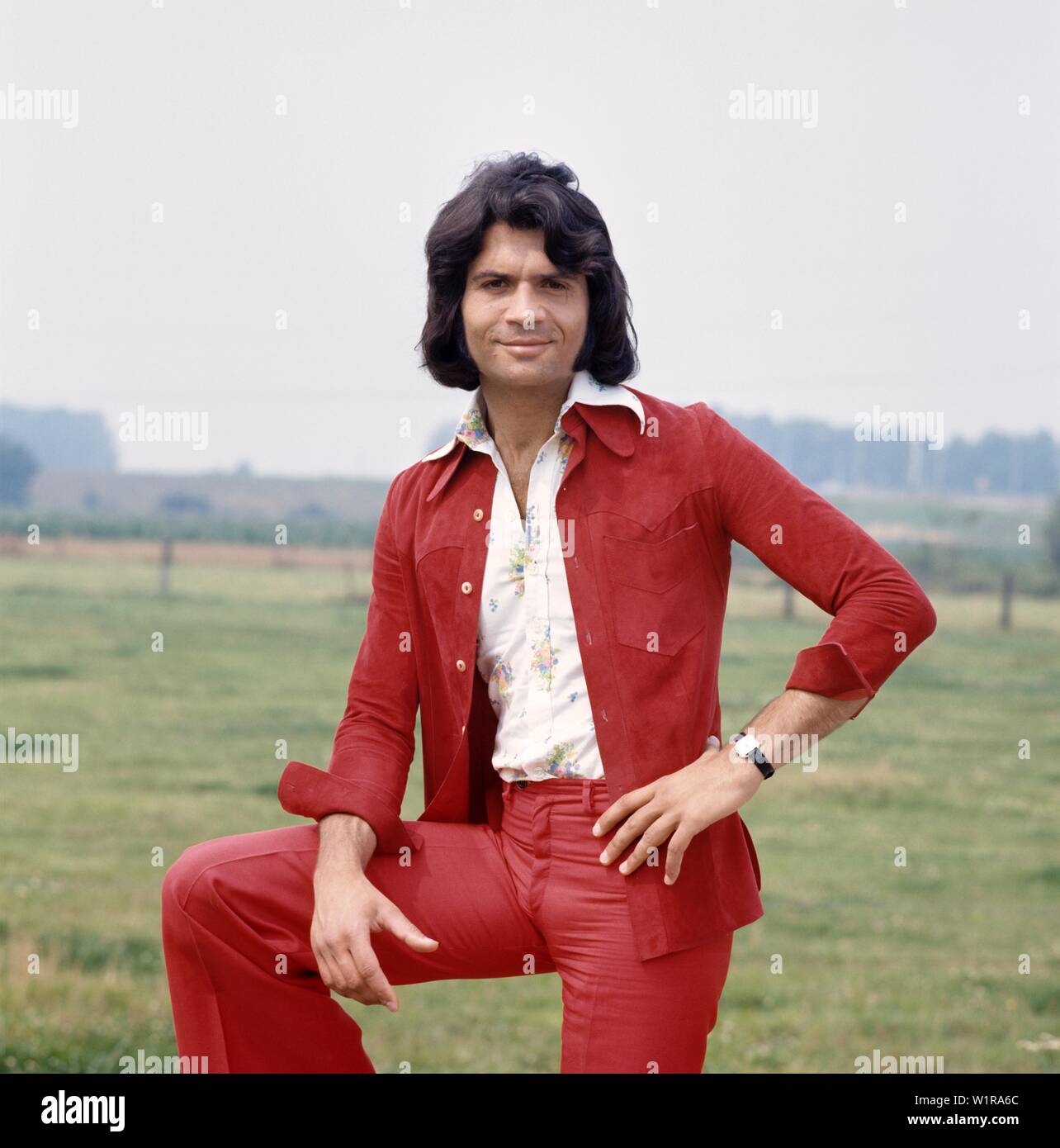 Musiker Costa Cordalis posiert für ein Fotoshooting in einem Feld. Musicien Costa Cordalis posant pour un photoshooting dans un champ. Banque D'Images