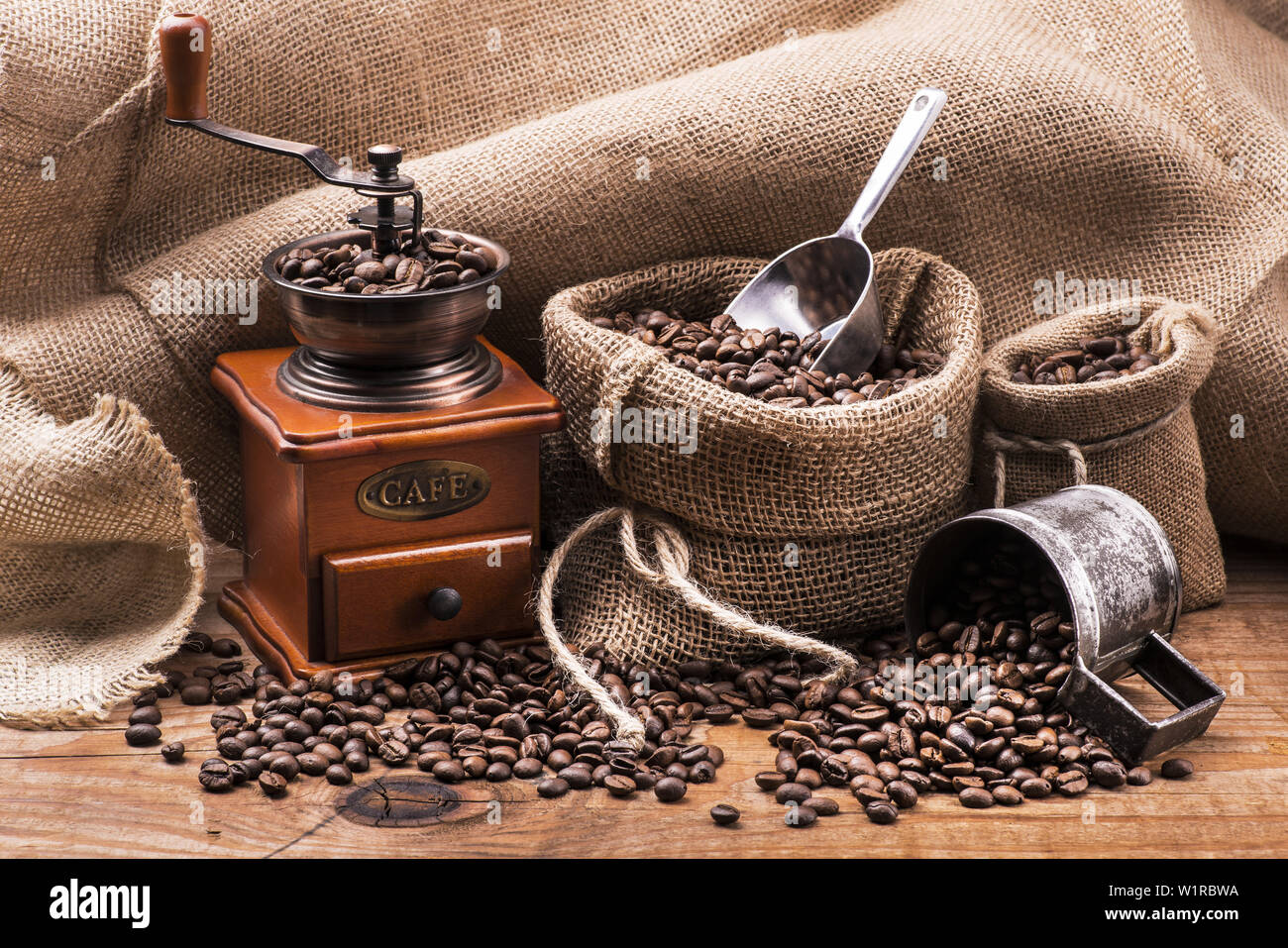 Les grains de café en sac de jute avec un moulin à café en bois Banque D'Images