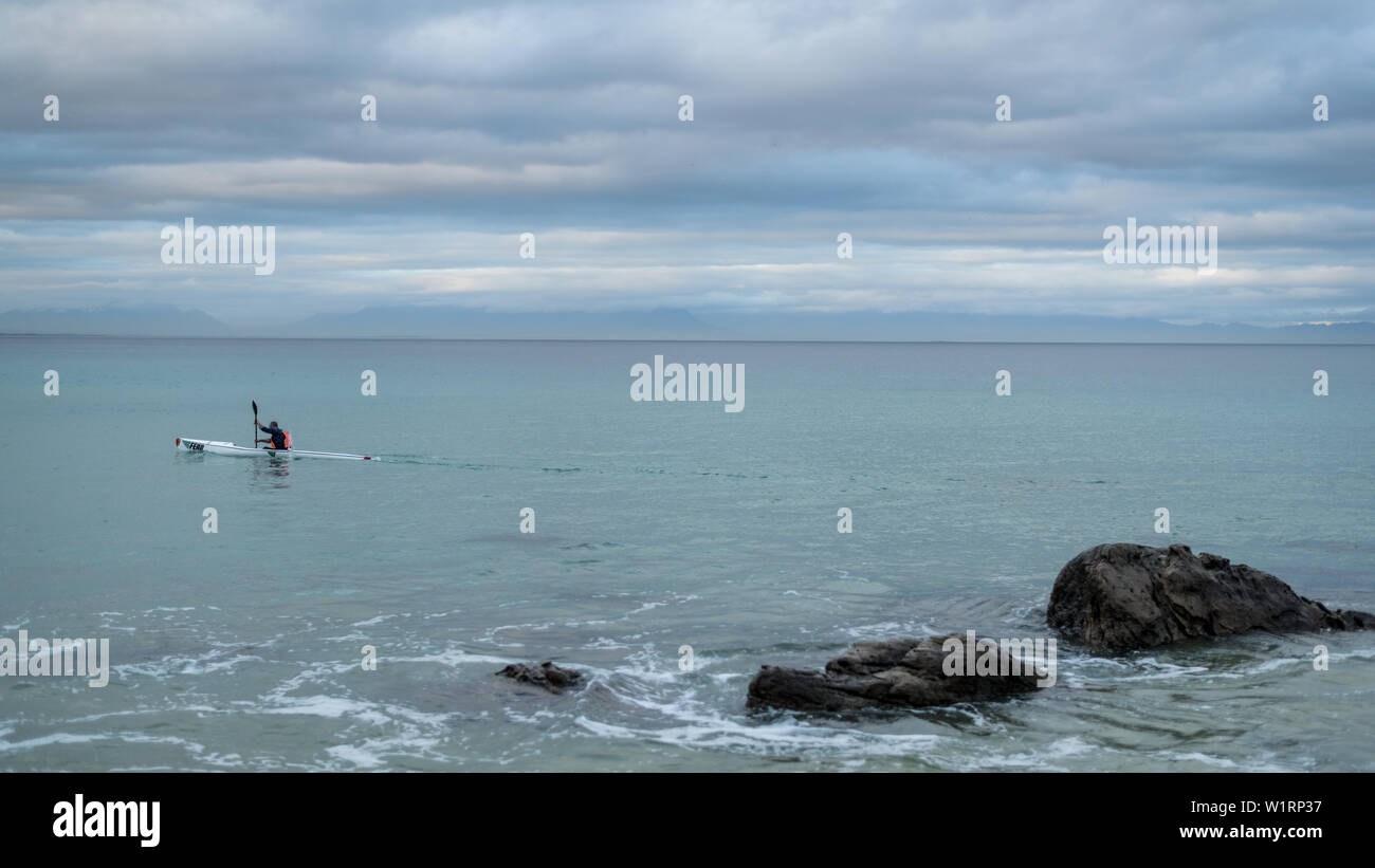 Un canoéiste paddles le long de la côte de False Bay pendant les mois d'hiver, près de Cape Town en Afrique du Sud Banque D'Images