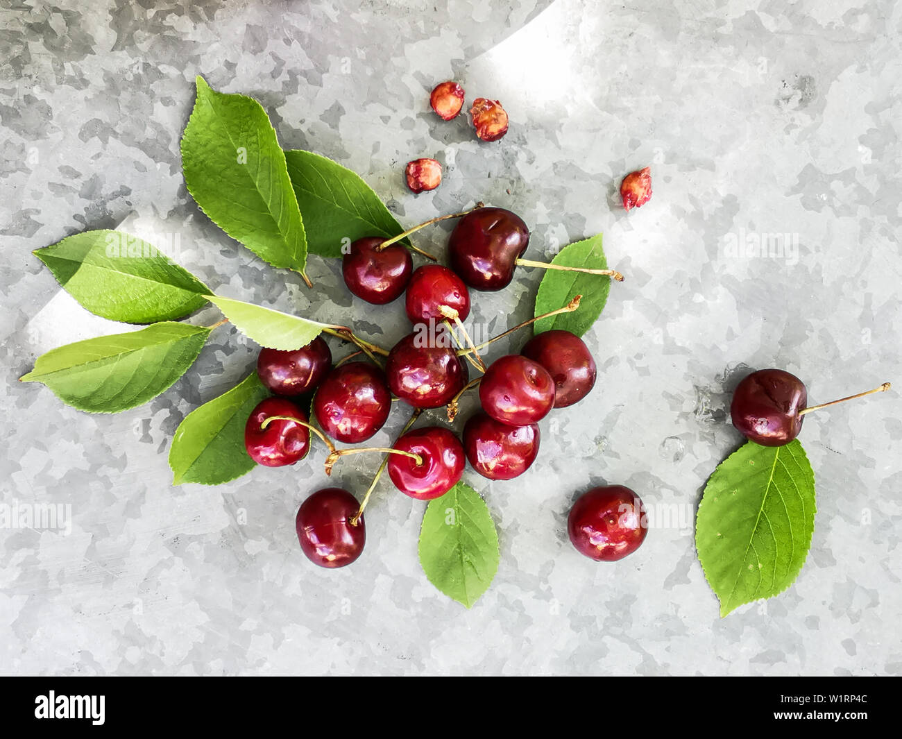 Belle cerise sur le tableau et sur la soucoupe. Des cerises et des noyaux de cerise, de puits sur une plaque Banque D'Images