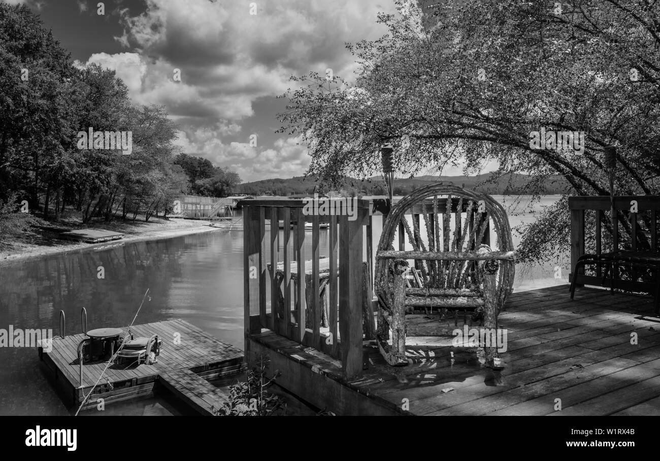 Rocking chair rustique sur terrasse en bois à l'ombre de l'arbre sur banque du lac dans les montagnes en été fumeurs près de Blue Ridge, Tennessee, USA. Banque D'Images