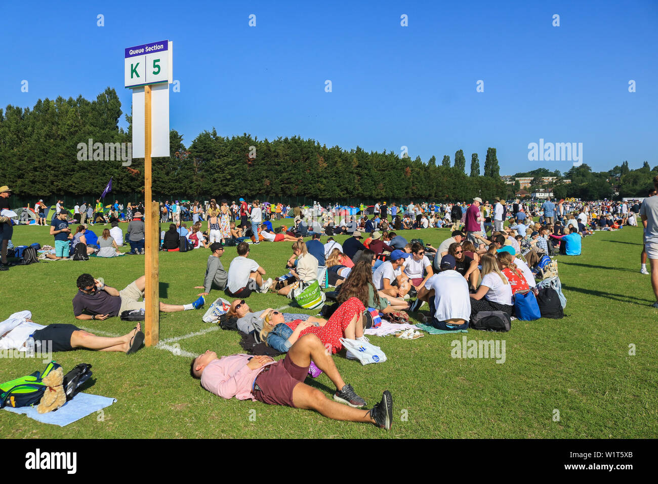 Des centaines de ticket d'attente des fans de tennis moins tôt le matin à l'extérieur le All England Lawn sur la troisième journée du championnat de Wimbledon. Banque D'Images