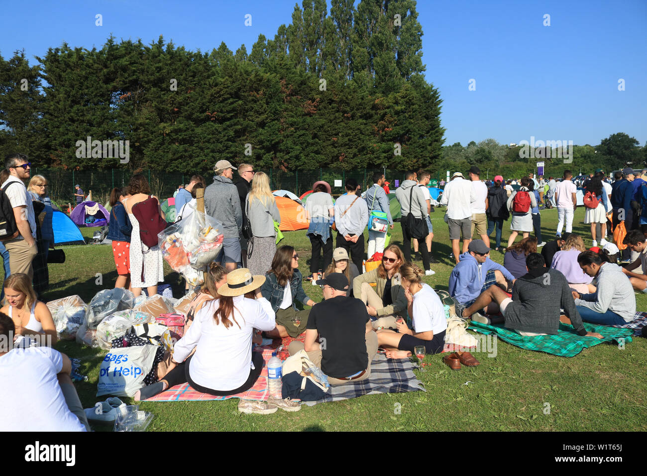 Des centaines de ticket d'attente des fans de tennis moins tôt le matin à l'extérieur le All England Lawn sur la troisième journée du championnat de Wimbledon. Banque D'Images
