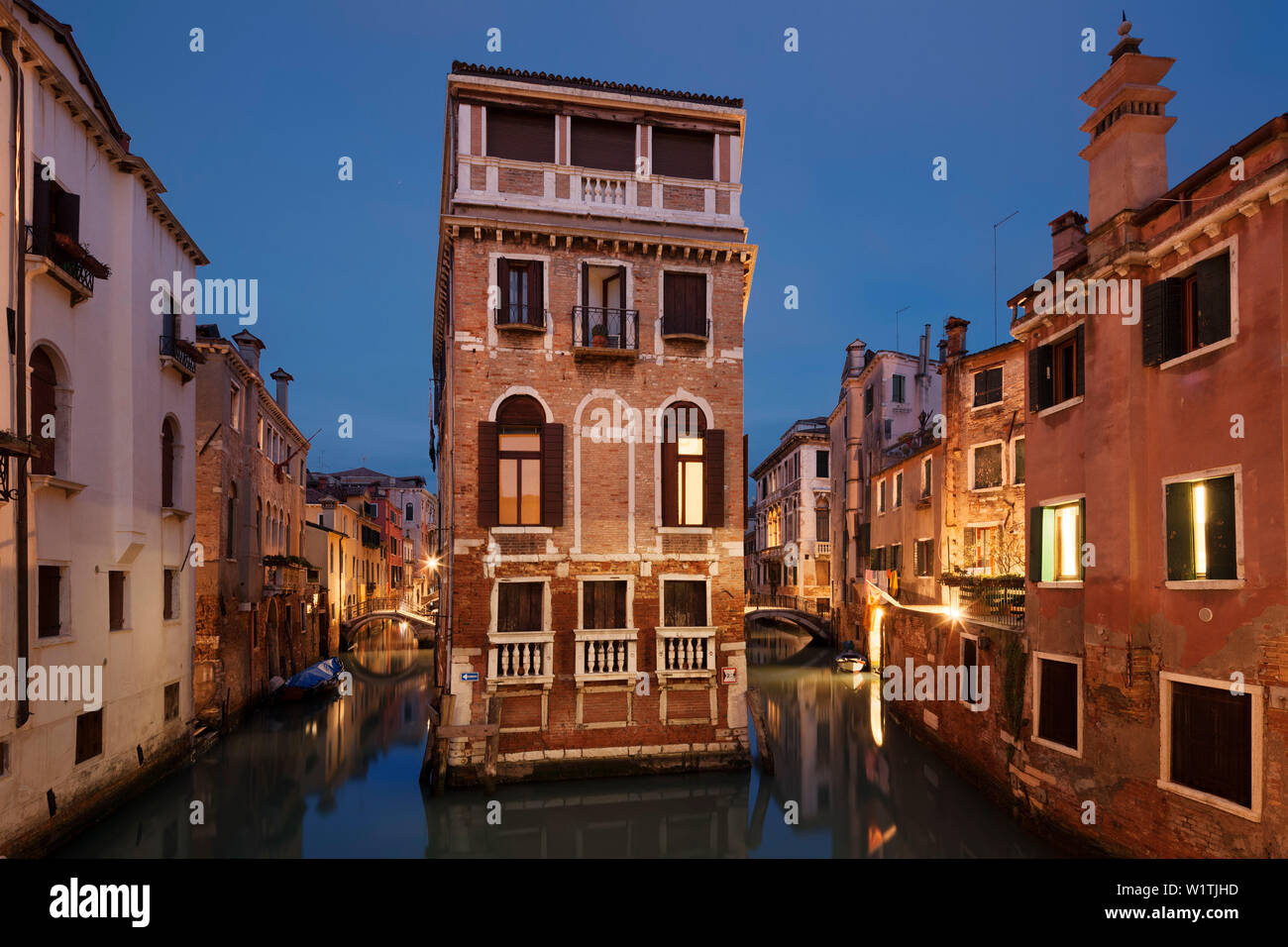 Maison illuminée entre les canaux Rio di San Giovanni Laterano et Rio de la Tetta en bleu crépuscule, Castello, Venise, Vénétie, Italie Banque D'Images