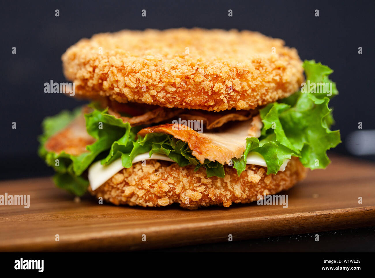 Sushi Burger avec une variété d'ingrédients savoureux sur fond sombre Banque D'Images