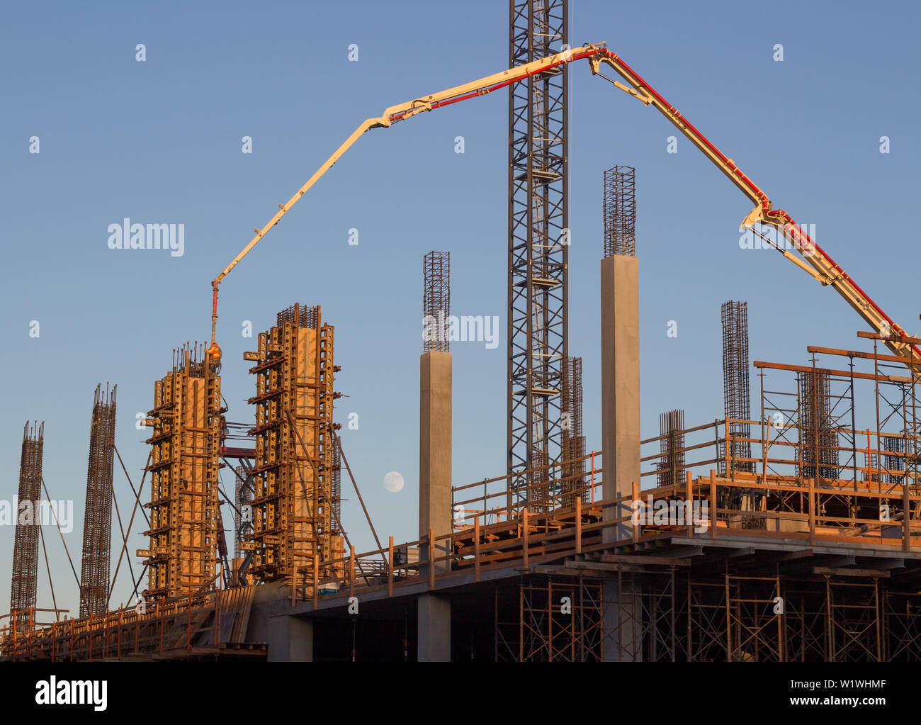 Nouvel immeuble de bureaux construction avec pompe à béton camion, d'échafaudages et de lune dans l'arrière-plan Banque D'Images