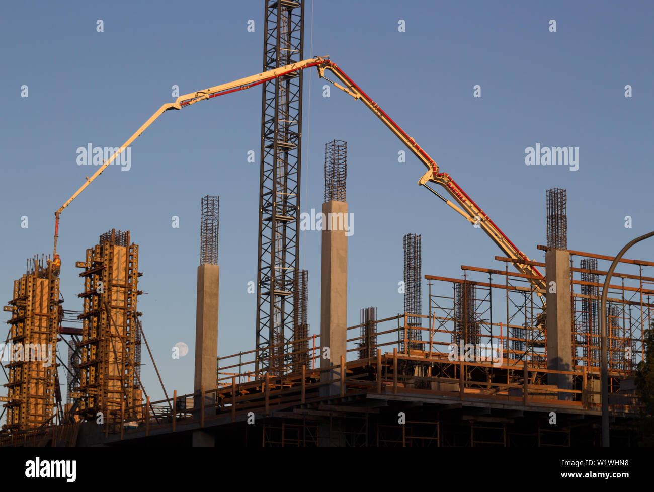 Nouvel immeuble de bureaux construction avec pompe à béton camion, d'échafaudages et de lune dans l'arrière-plan Banque D'Images
