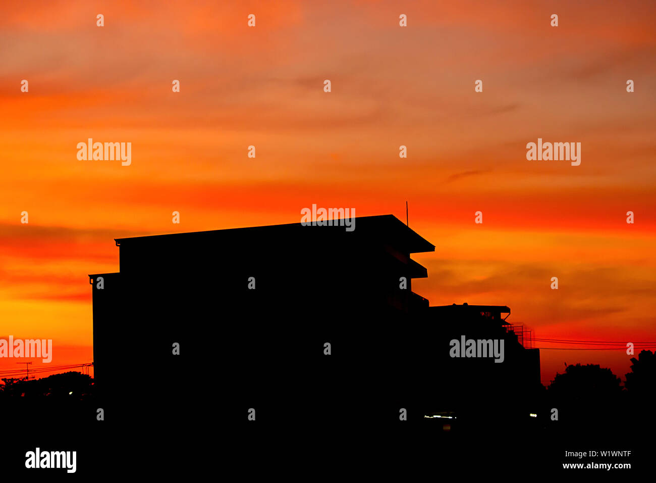 Belle Lumière du coucher de soleil avec des nuages dans le ciel la réflexion derrière le bâtiment. Banque D'Images