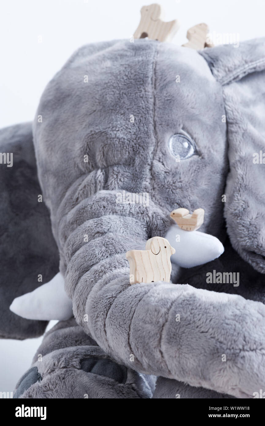 Jouet en bois mignon animaux sur la planche en bois blanc avec poupée éléphant géant dans l'arrière-plan, petits jouets et profondeur de champ Banque D'Images