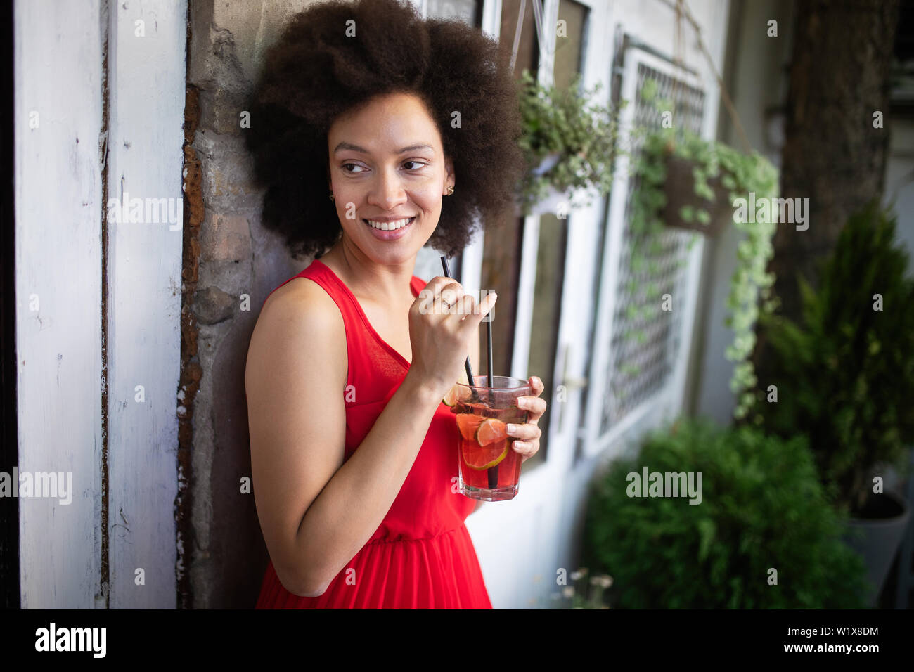 Mode de vie portrait of woman posing sur la rue avec verre Banque D'Images