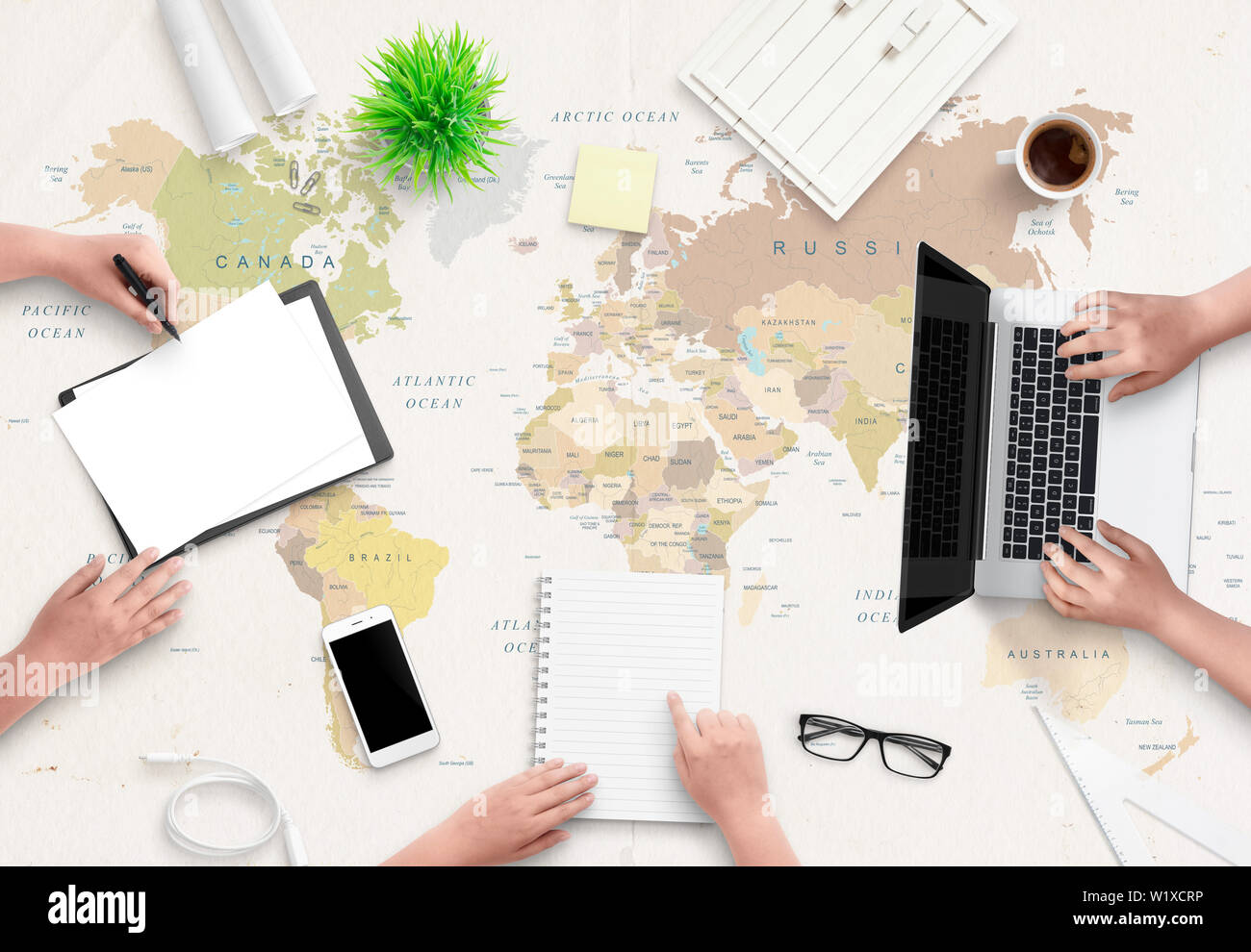 Concept Bureau de l'agence de voyages. Les gens travaillent avec des papiers et un ordinateur. Carte du monde en arrière-plan. Mise à plat, vue du dessus. Banque D'Images