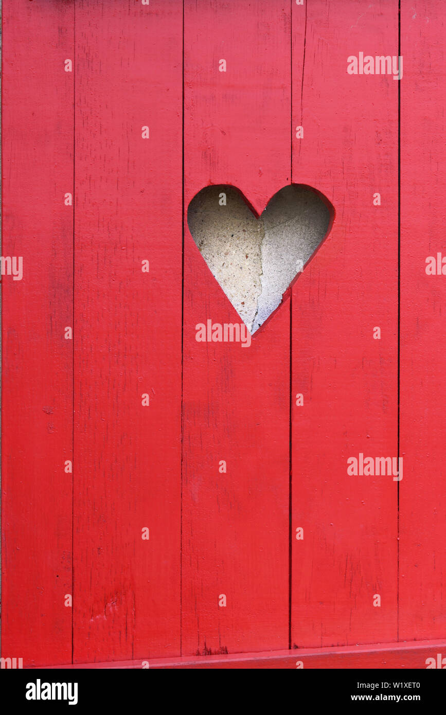 Fermer sur une forme de coeur sur un volet en bois rouge Banque D'Images