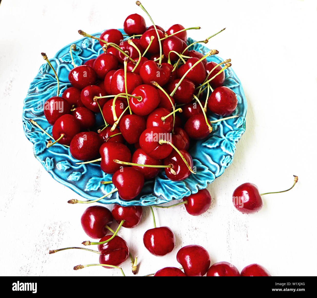 Les cerises mûres rouges sur une plaque bleue prêt à manger Banque D'Images