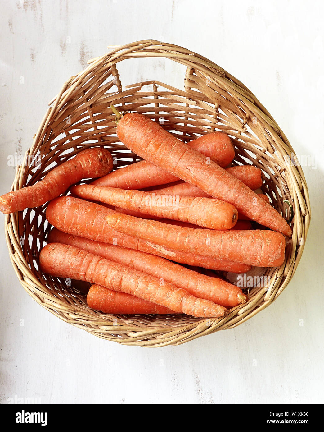 Les carottes avec des couleurs vives dans un panier sur la table de cuisine Banque D'Images