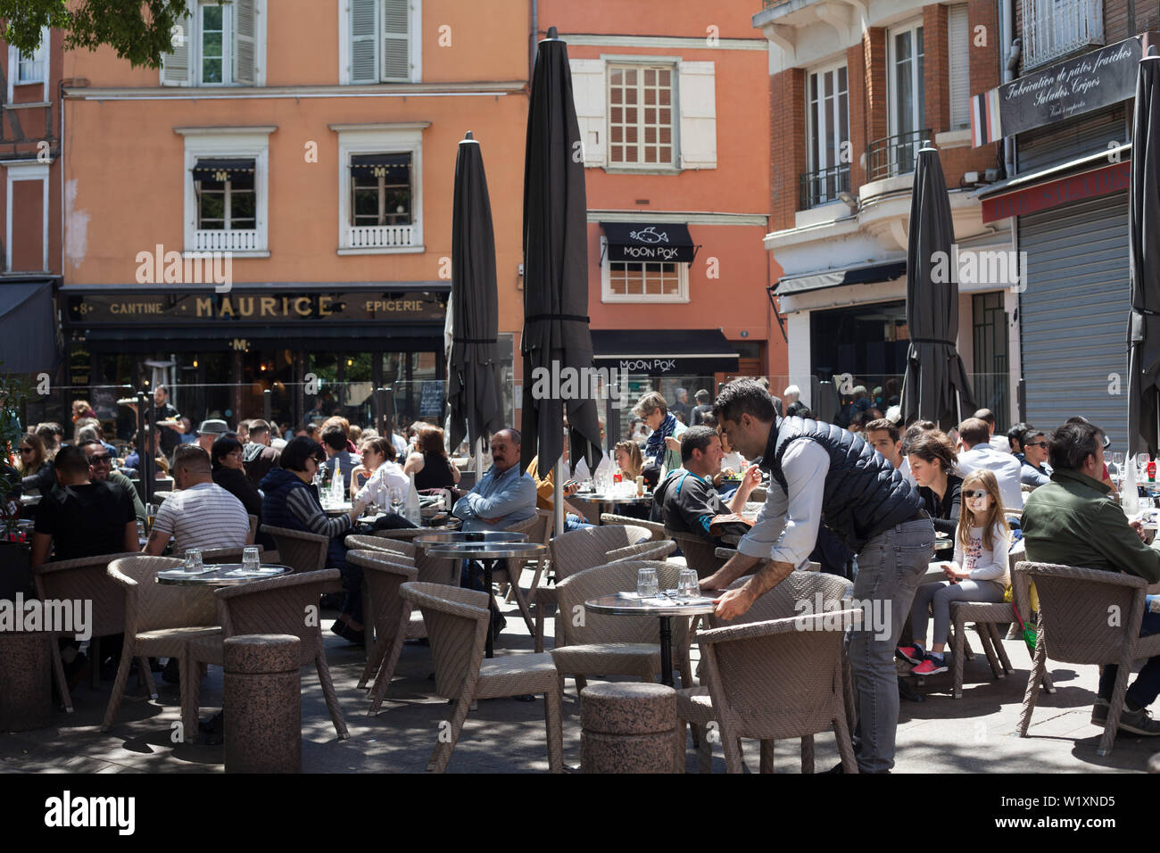 Les personnes appréciant le déjeuner al fresco dans les restaurants en place St Georges, Toulouse, Haute-Garonne, Occitanie, France Banque D'Images