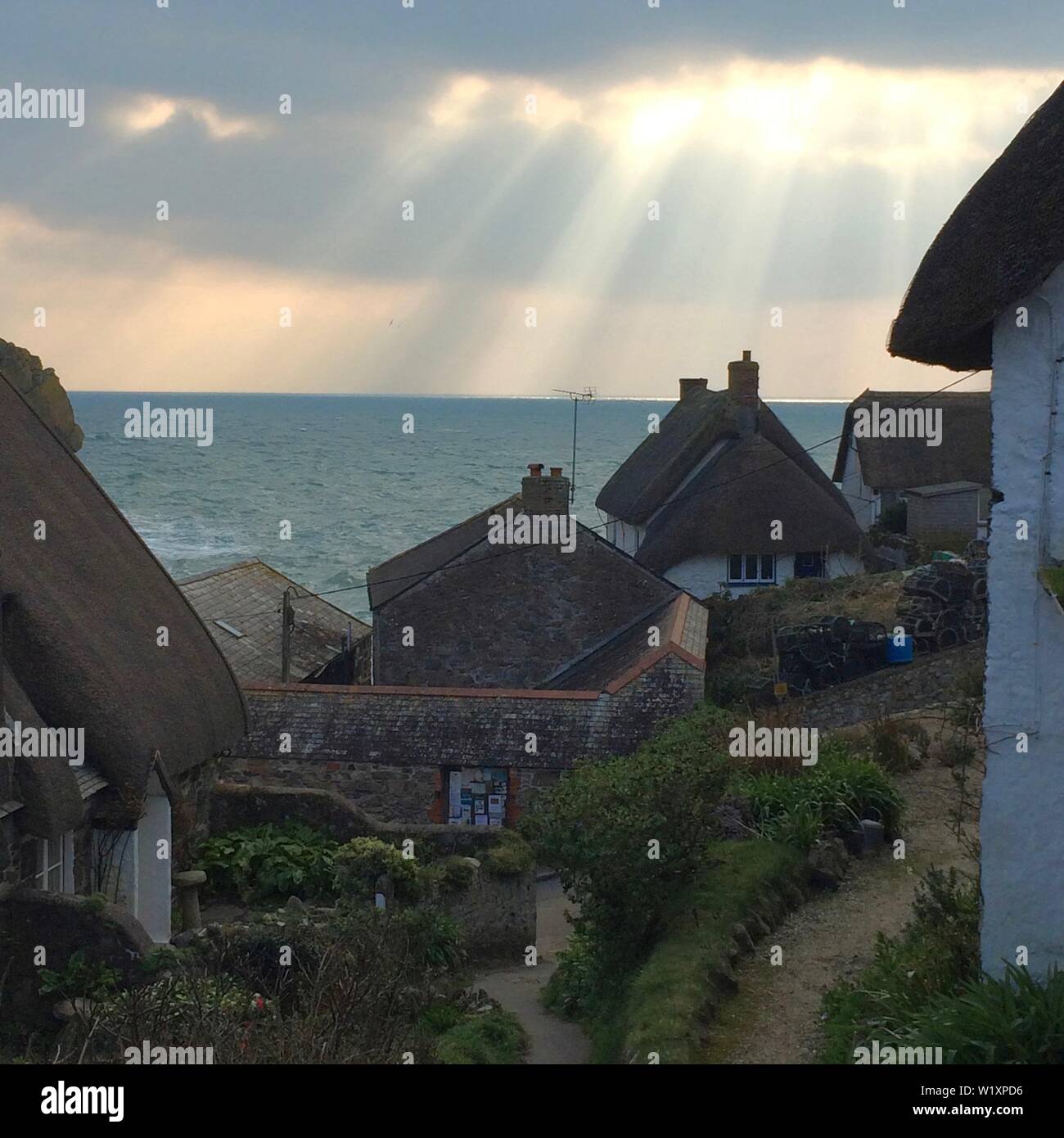 La lumière du soleil transperce plus Cadgwith Cove, Cornwall Banque D'Images