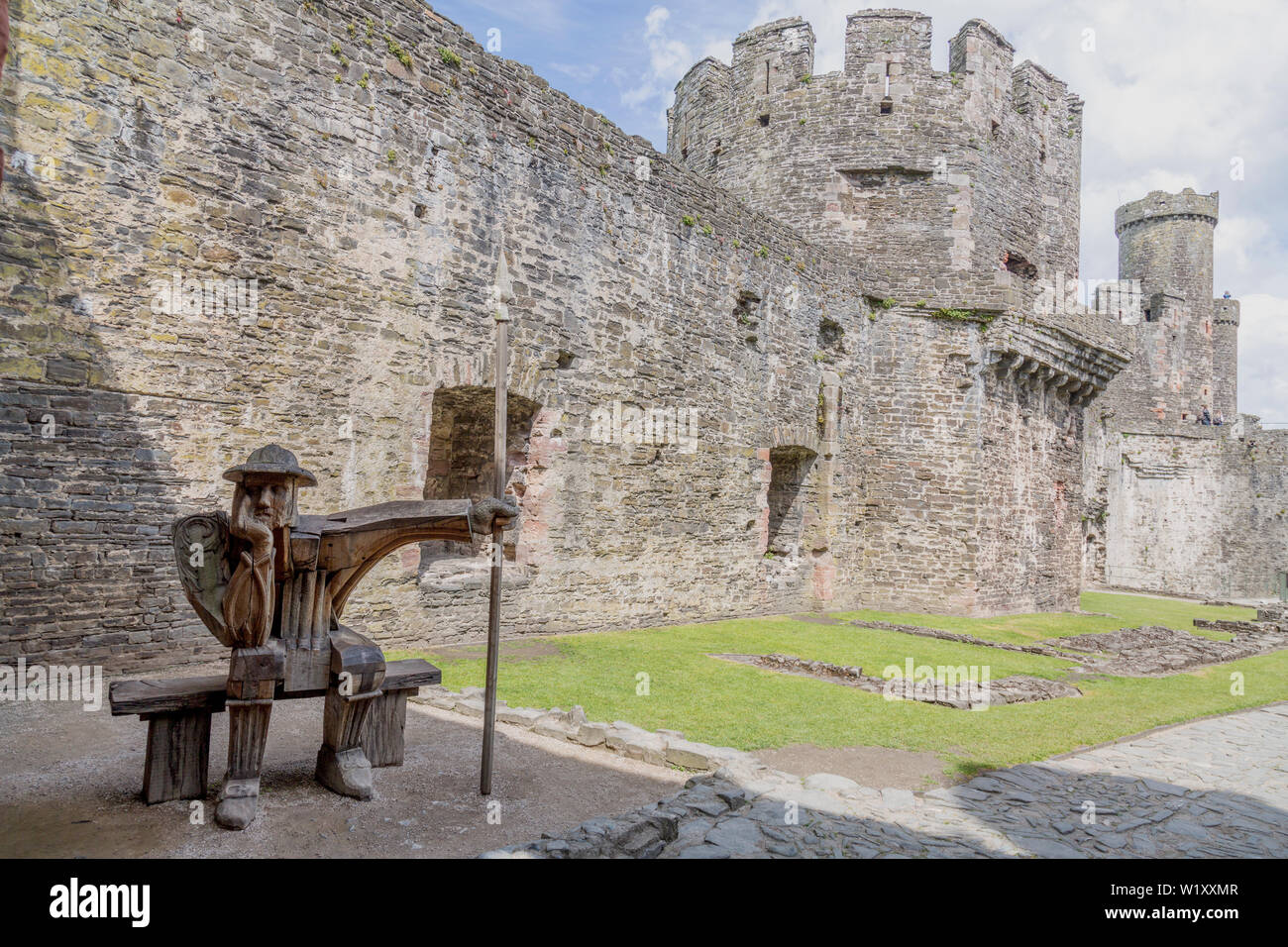 "La Garde" une sculpture en chêne en bois par John Merrill à l'intérieur des ruines du Château de Conwy, Pays de Galles, Royaume-Uni Banque D'Images