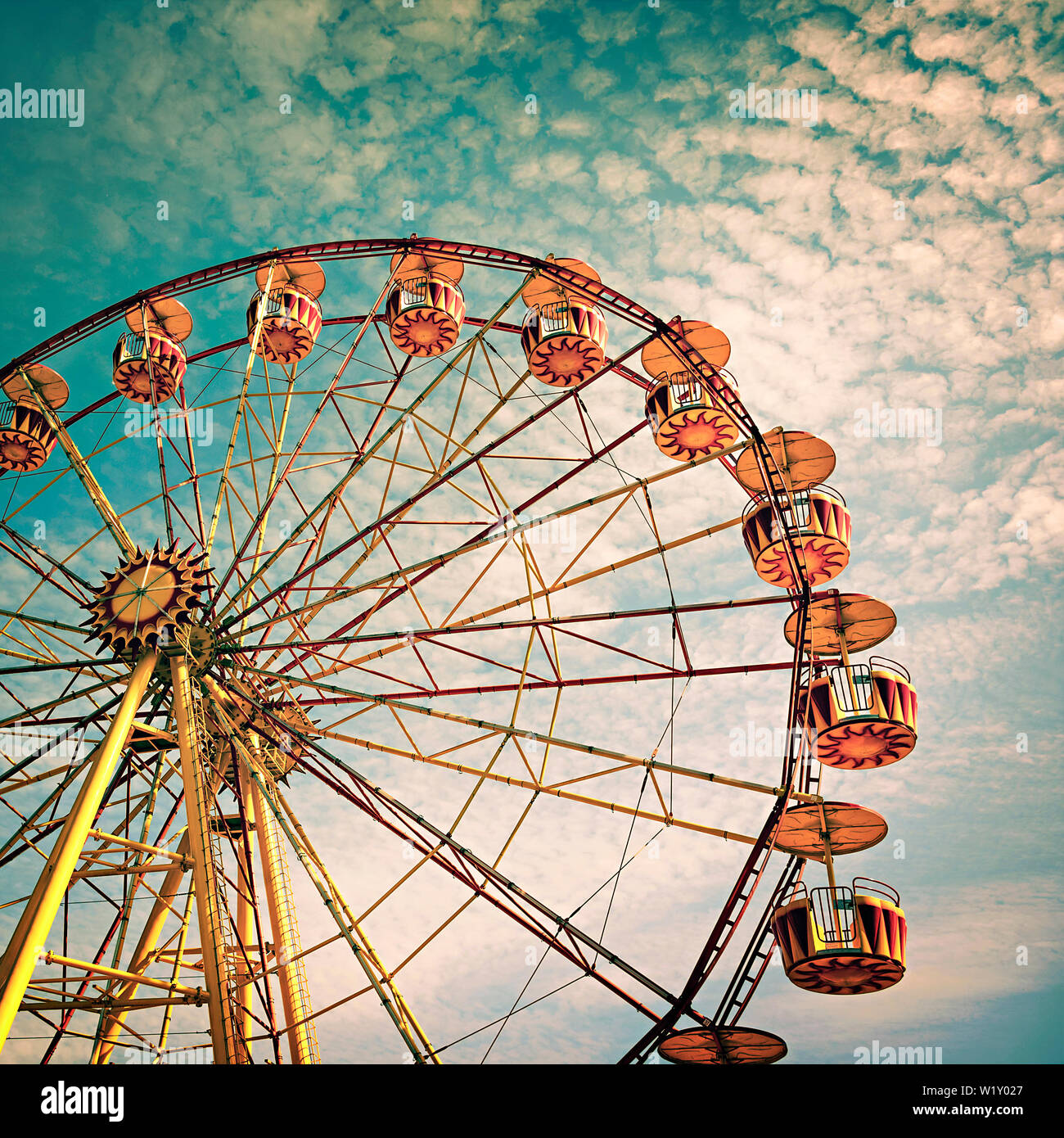 Grande roue jaune contre un ciel bleu dans un style vintage Banque D'Images