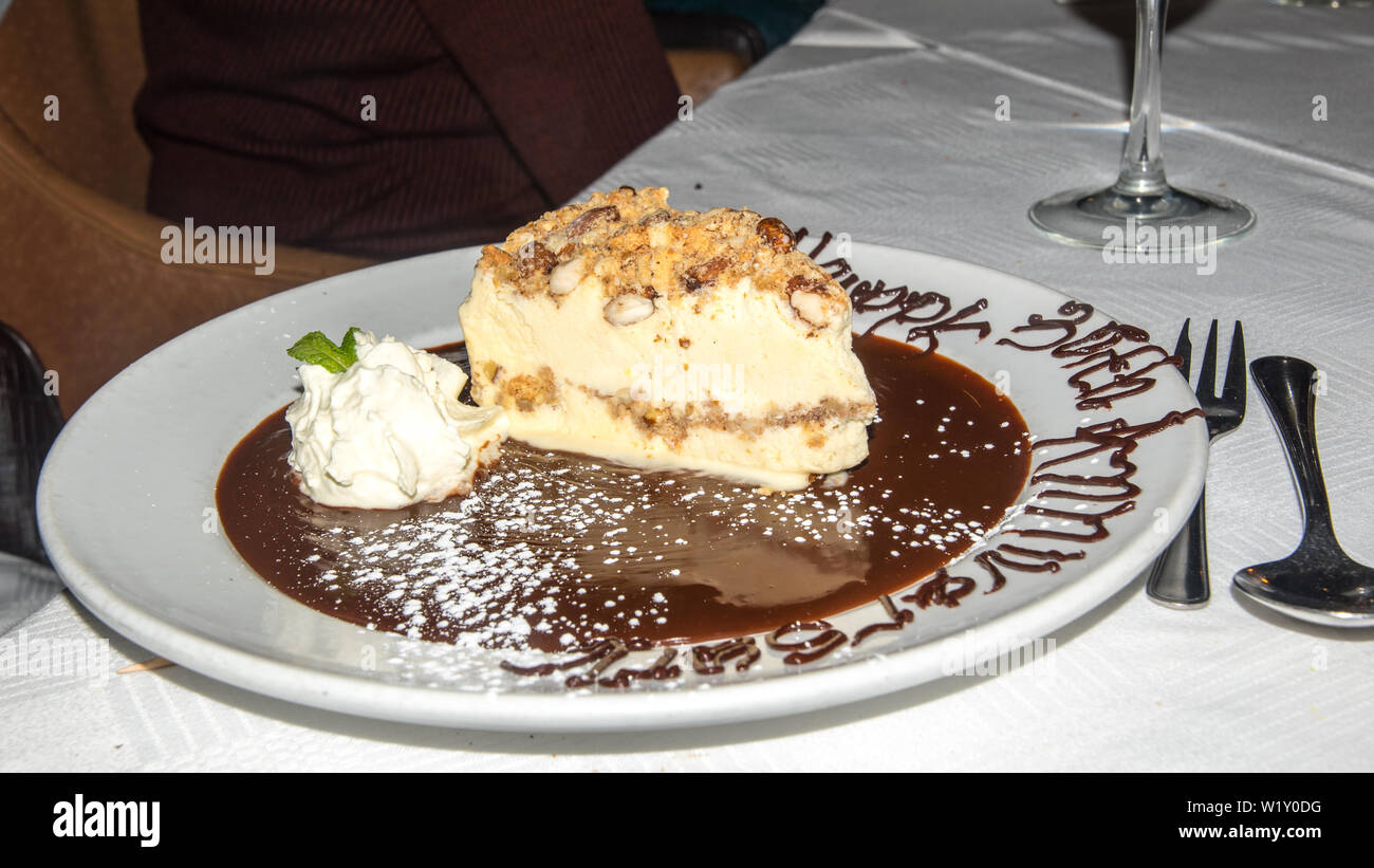 La photo en gros de produits gourmet dessert servi à table au dîner romantique aux chandelles. C'est un écrou tranche de gâteau servi avec une délicieuse sauce au chocolat. Banque D'Images